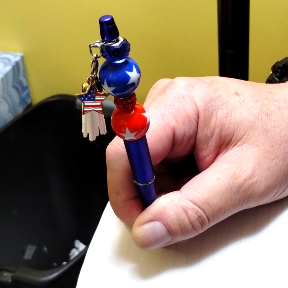 Blue pen with white tassell and a star flag.